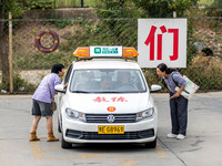 Students learn about the advantages of AI intelligent coaching cars at Blue Shield Intelligent Driving School in Huaxian County, Anyang, Chi...