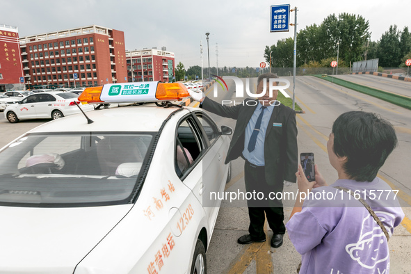 Students learn about the advantages of AI intelligent coaching cars at Blue Shield Intelligent Driving School in Huaxian County, Anyang, Chi...