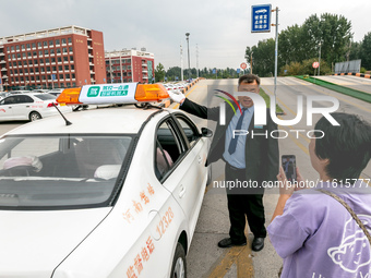 Students learn about the advantages of AI intelligent coaching cars at Blue Shield Intelligent Driving School in Huaxian County, Anyang, Chi...