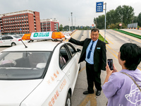 Students learn about the advantages of AI intelligent coaching cars at Blue Shield Intelligent Driving School in Huaxian County, Anyang, Chi...