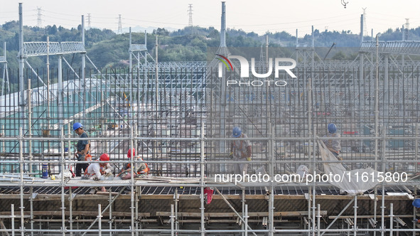 Construction workers work at the construction site of the 800 kV Yubei converter station in Chongqing, China, on September 28, 2024. 