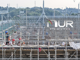 Construction workers work at the construction site of the 800 kV Yubei converter station in Chongqing, China, on September 28, 2024. (