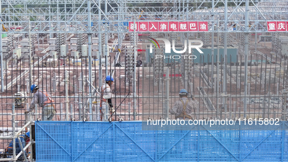 Construction workers work at the construction site of the 800 kV Yubei converter station in Chongqing, China, on September 28, 2024. 