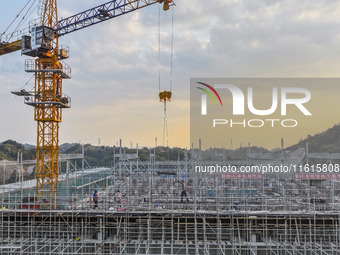 Construction workers work at the construction site of the 800 kV Yubei converter station in Chongqing, China, on September 28, 2024. (