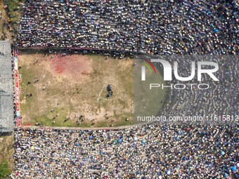 People watch a bullfight at the Songxue bullfight pond in Congjiang county, Southwest China's Guizhou province, on September 28, 2024. (