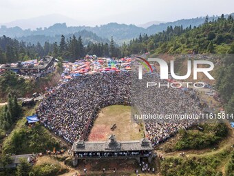 People watch a bullfight at the Songxue bullfight pond in Congjiang county, Southwest China's Guizhou province, on September 28, 2024. (