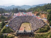 People watch a bullfight at the Songxue bullfight pond in Congjiang county, Southwest China's Guizhou province, on September 28, 2024. (