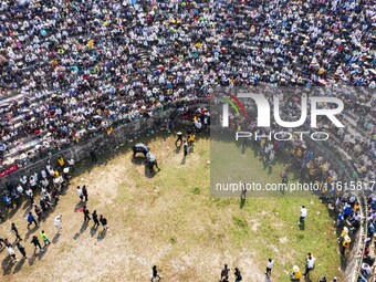 People watch a bullfight at the Songxue bullfight pond in Congjiang county, Southwest China's Guizhou province, on September 28, 2024. (