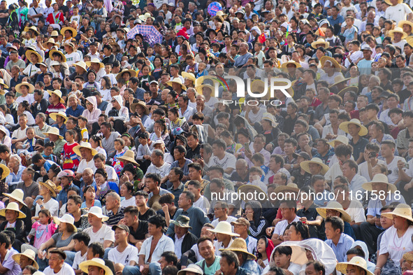 People watch a bullfight at the Songxue bullfight pond in Congjiang county, Southwest China's Guizhou province, on September 28, 2024. 