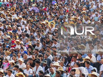 People watch a bullfight at the Songxue bullfight pond in Congjiang county, Southwest China's Guizhou province, on September 28, 2024. (