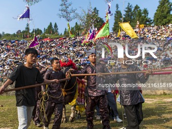 People watch a bullfight at the Songxue bullfight pond in Congjiang county, Southwest China's Guizhou province, on September 28, 2024. (