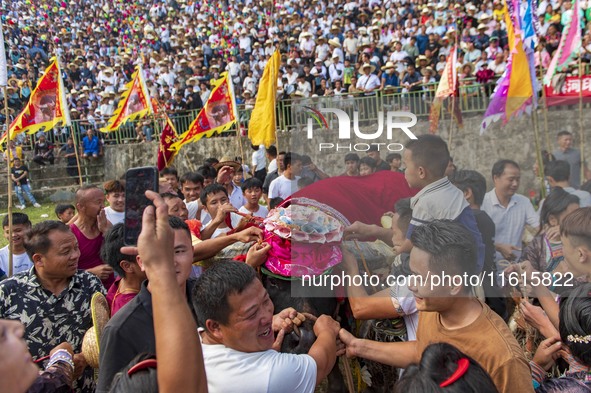 People watch a bullfight at the Songxue bullfight pond in Congjiang county, Southwest China's Guizhou province, on September 28, 2024. 