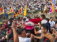 People watch a bullfight at the Songxue bullfight pond in Congjiang county, Southwest China's Guizhou province, on September 28, 2024. (