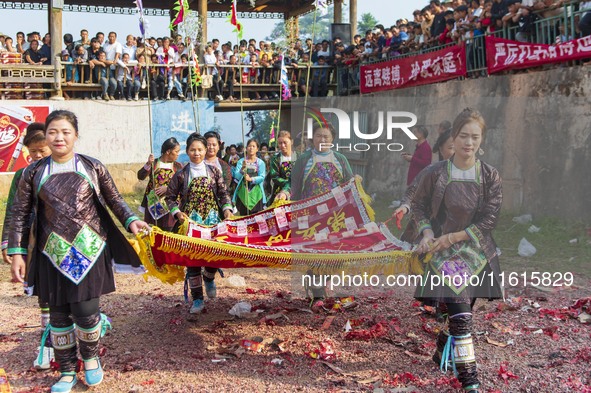 People watch a bullfight at the Songxue bullfight pond in Congjiang county, Southwest China's Guizhou province, on September 28, 2024. 