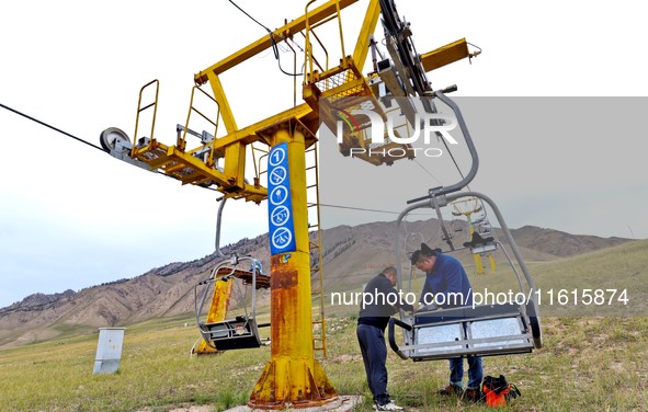 Staff members check the safety operation of the gondola at the Qilian Mountain ski resort in Zhangye, China, on September 28, 2024. 