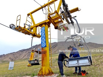 Staff members check the safety operation of the gondola at the Qilian Mountain ski resort in Zhangye, China, on September 28, 2024. (