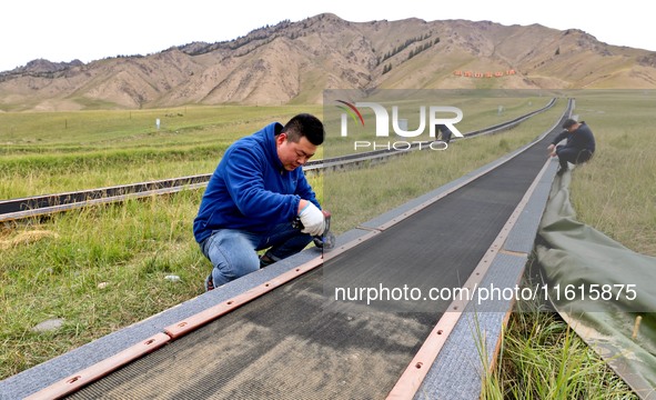 Staff members check the safety operation of the gondola at the Qilian Mountain ski resort in Zhangye, China, on September 28, 2024. 