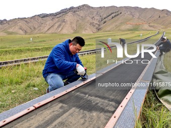 Staff members check the safety operation of the gondola at the Qilian Mountain ski resort in Zhangye, China, on September 28, 2024. (