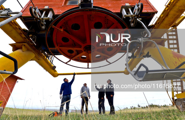 Staff members check the safety operation of the gondola at the Qilian Mountain ski resort in Zhangye, China, on September 28, 2024. 