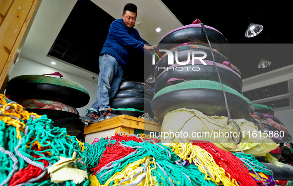 A staff member repairs a ski ring at the Qilian Mountain ski resort in Zhangye, China, on September 28, 2024. 