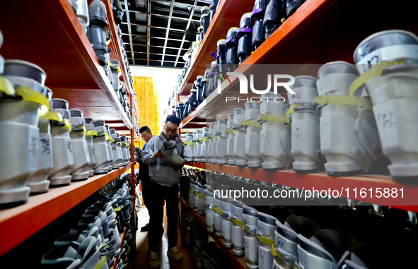 Staff members repair ski boots at the Qilian Mountain ski resort in Zhangye, China, on September 28, 2024. 