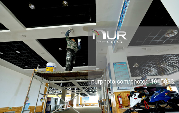 Staff work on the interior renovation of the visitor center at the Qilian Mountain ski resort in Zhangye, China, on September 28, 2024. 