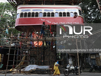 Artisans clean a model of a tram on a temporary platform ahead of the Durga Puja festival in Kolkata, India, on September 28, 2024. The annu...