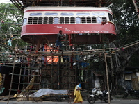 Artisans clean a model of a tram on a temporary platform ahead of the Durga Puja festival in Kolkata, India, on September 28, 2024. The annu...