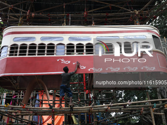 Artisans clean a model of a tram on a temporary platform ahead of the Durga Puja festival in Kolkata, India, on September 28, 2024. The annu...