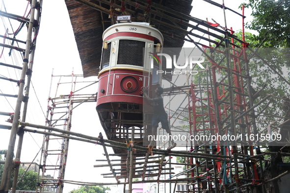 An artisan cleans a model of a tram on a temporary platform ahead of the Durga Puja festival in Kolkata, India, on September 28, 2024. The a...