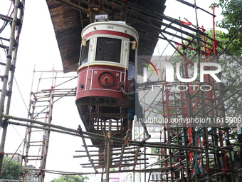 An artisan cleans a model of a tram on a temporary platform ahead of the Durga Puja festival in Kolkata, India, on September 28, 2024. The a...