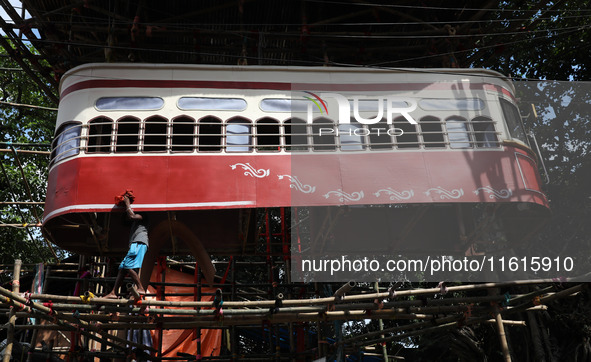 An artisan cleans a model of a tram on a temporary platform ahead of the Durga Puja festival in Kolkata, India, on September 28, 2024. The a...