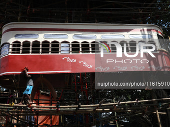 An artisan cleans a model of a tram on a temporary platform ahead of the Durga Puja festival in Kolkata, India, on September 28, 2024. The a...