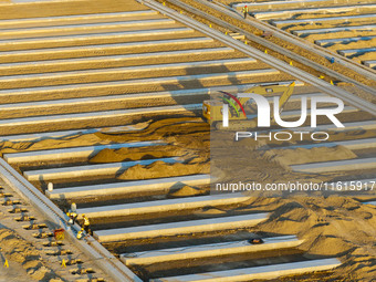 Workers work at the construction site of the third phase of the Canal New Port operation zone in Huai'an, China, on September 28, 2024. (