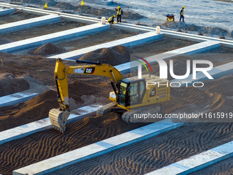 Workers work at the construction site of the third phase of the Canal New Port operation zone in Huai'an, China, on September 28, 2024. (