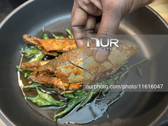 Sardines coated with masala spices fry in a pan as Kerala style mathi fry (sardine fish fry) is prepared in Toronto, Ontario, Canada, on Sep...