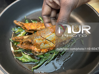 Sardines coated with masala spices fry in a pan as Kerala style mathi fry (sardine fish fry) is prepared in Toronto, Ontario, Canada, on Sep...