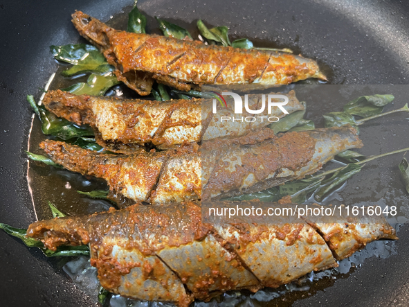 Sardines coated with masala spices fry in a pan as Kerala style mathi fry (sardine fish fry) is prepared in Toronto, Ontario, Canada, on Sep...