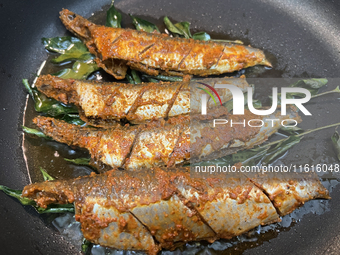 Sardines coated with masala spices fry in a pan as Kerala style mathi fry (sardine fish fry) is prepared in Toronto, Ontario, Canada, on Sep...