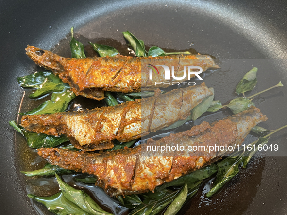 Sardines coated with masala spices fry in a pan as Kerala style mathi fry (sardine fish fry) is prepared in Toronto, Ontario, Canada, on Sep...