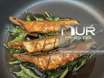 Sardines coated with masala spices fry in a pan as Kerala style mathi fry (sardine fish fry) is prepared in Toronto, Ontario, Canada, on Sep...