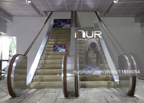 An artisan works inside a model of Howrah Maidan metro station escalators in a ''pandal'' or a temporary platform ahead of the Durga Puja fe...