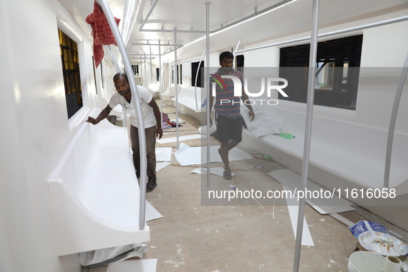 Artisans work inside a model of a metro compartment in a ''pandal'' or a temporary platform ahead of the Durga Puja festival in India on Sep...