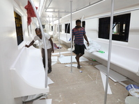 Artisans work inside a model of a metro compartment in a ''pandal'' or a temporary platform ahead of the Durga Puja festival in India on Sep...