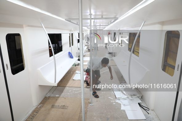 Artisans work inside a model of a metro compartment in a ''pandal'' or a temporary platform ahead of the Durga Puja festival in India on Sep...