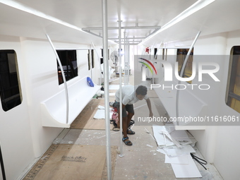 Artisans work inside a model of a metro compartment in a ''pandal'' or a temporary platform ahead of the Durga Puja festival in India on Sep...