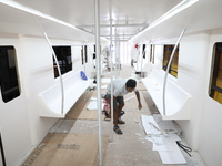 Artisans work inside a model of a metro compartment in a ''pandal'' or a temporary platform ahead of the Durga Puja festival in India on Sep...