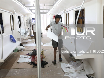 Artisans work inside a model of a metro compartment in a ''pandal'' or a temporary platform ahead of the Durga Puja festival in India on Sep...