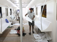 Artisans work inside a model of a metro compartment in a ''pandal'' or a temporary platform ahead of the Durga Puja festival in India on Sep...