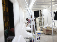 Artisans work inside a model of a metro compartment in a ''pandal'' or a temporary platform ahead of the Durga Puja festival in India on Sep...